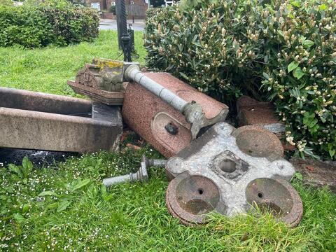 Horse trough on its side tipped over onto the green grass